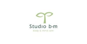 Logo-StudioBM Logo van Studio B|M – Body & Mind Care, met een gestileerde groene plantvorm boven de bedrijfsnaam in een zachte, groene typografie.